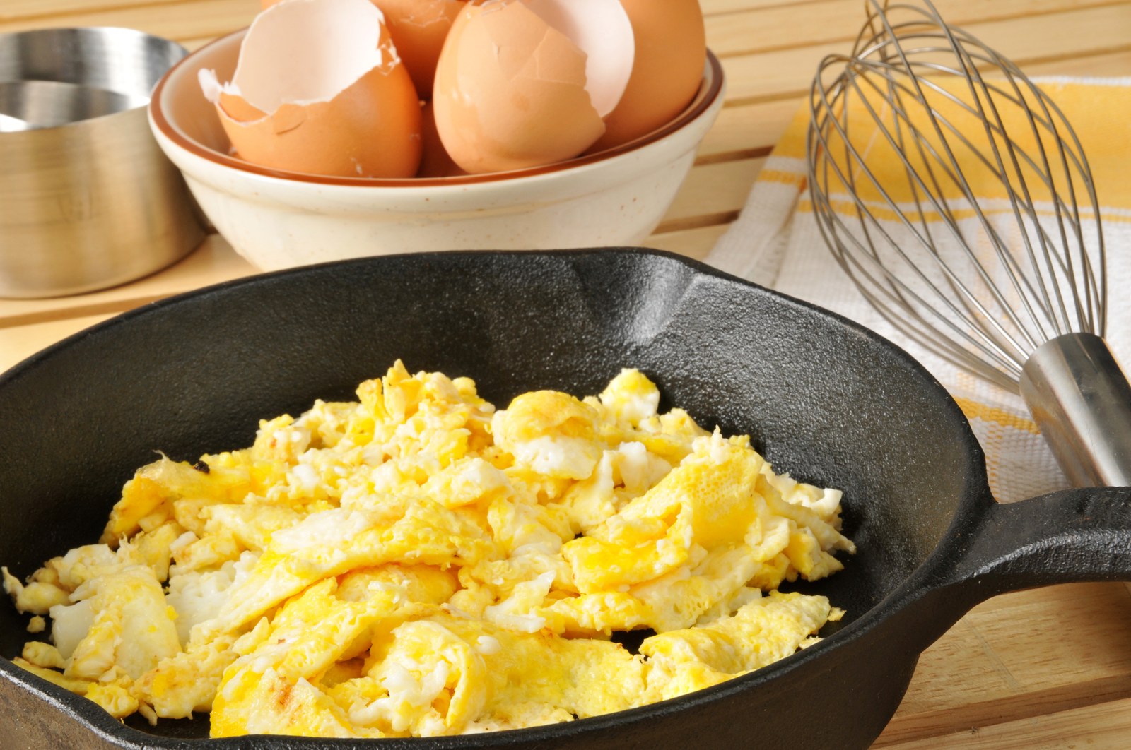 Soft creamy scrambled eggs with butter in a skillet.