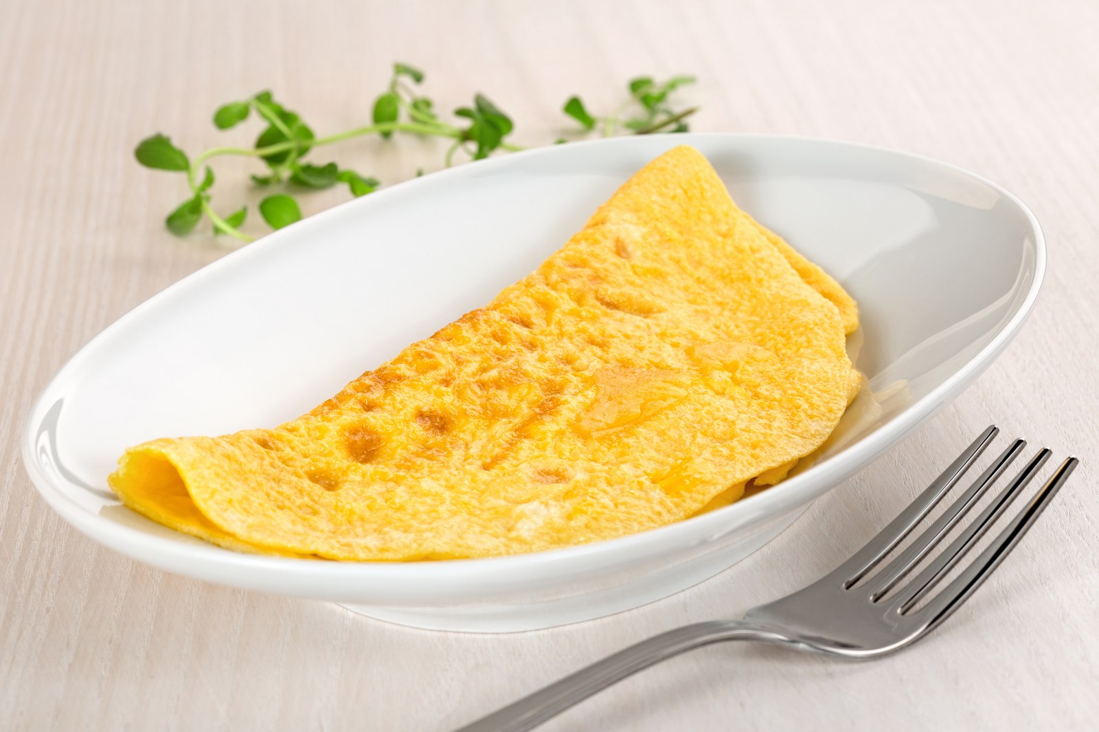 Classic French omelette folded in thirds on a white oval plate
