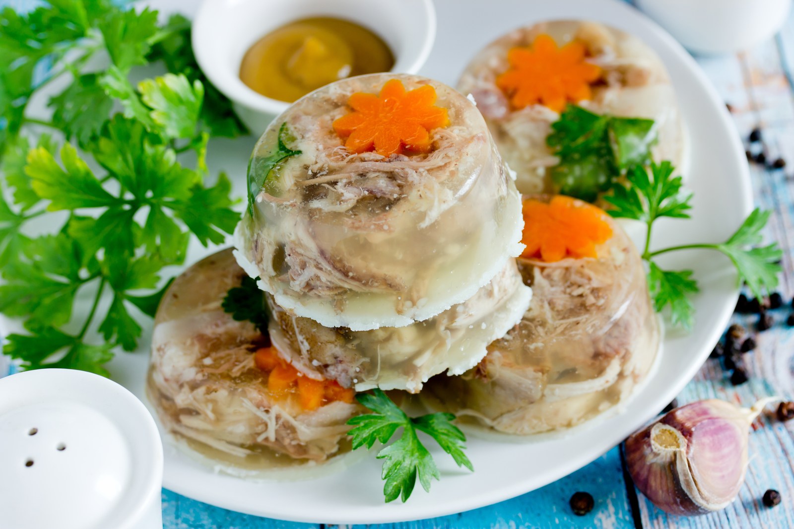Stacked rounds of Greek hilopites pasta in aspic garnished with carrot flowers and fresh herbs
