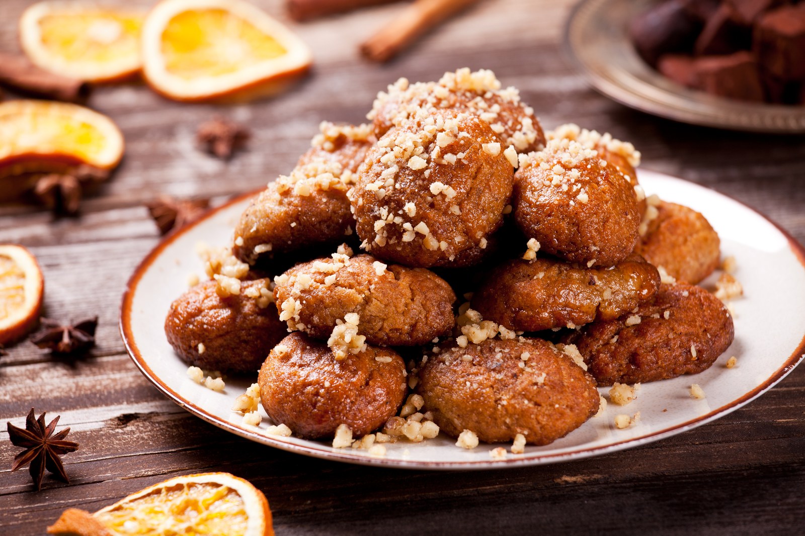 Stack of oval-shaped Greek honey cookies coated with chopped walnuts