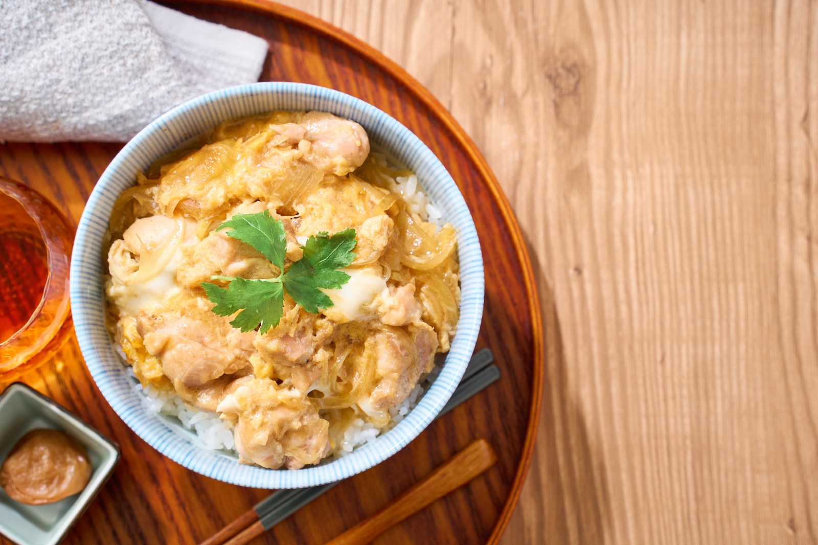 Japanese rice bowl topped with chicken, egg, and onions in savory sauce