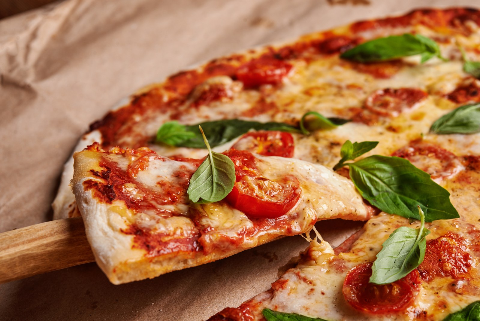 Classic Margherita pizza with tomato sauce, melted mozzarella, fresh basil, and sliced tomatoes