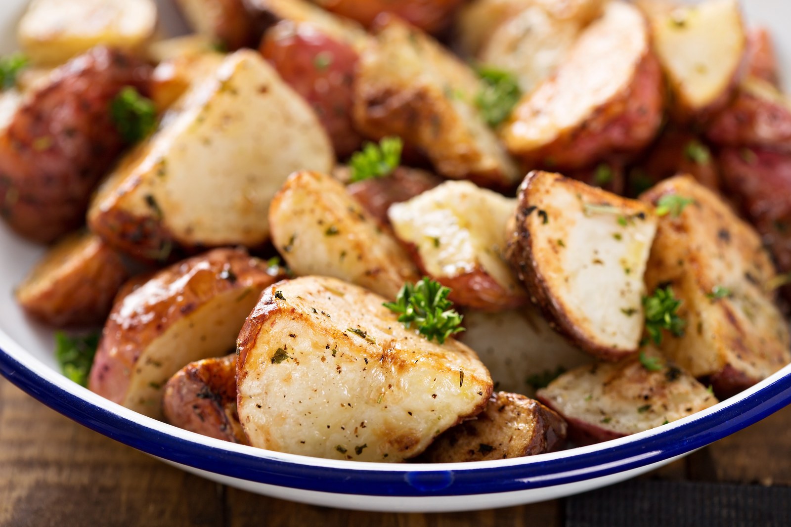 Bowl of golden roasted potato wedges seasoned with herbs and salt