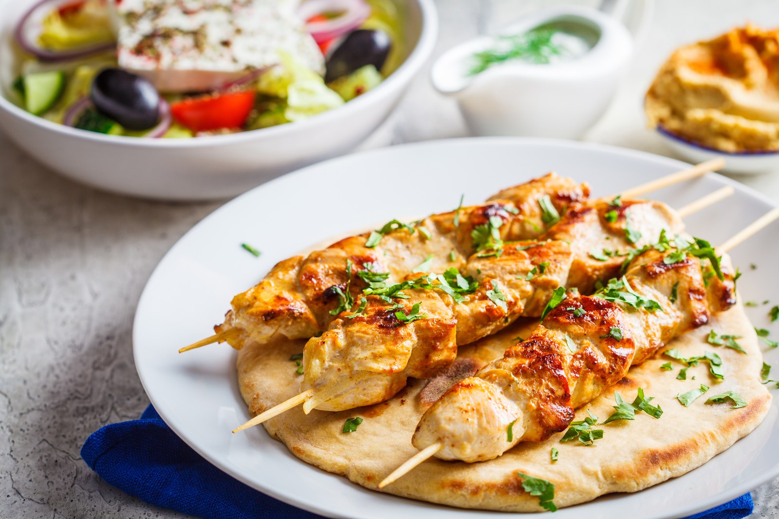Grilled chicken souvlaki skewers served on pita bread with fresh herb