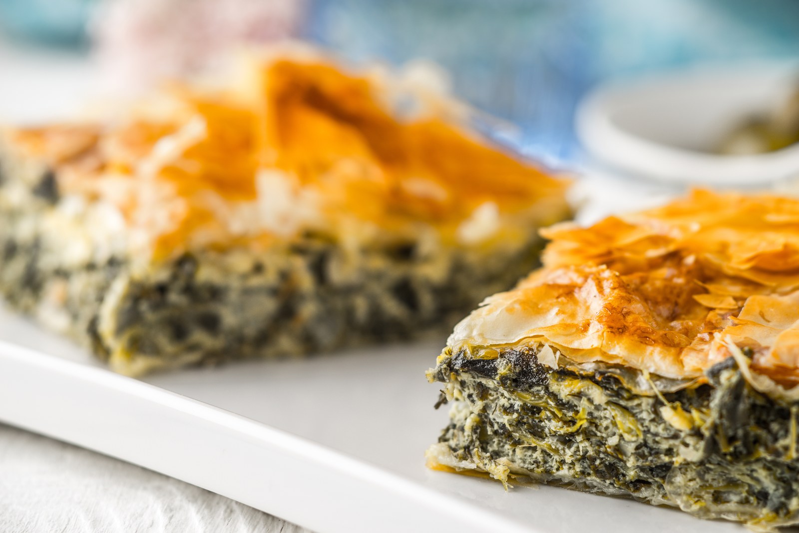 Sliced Greek spinach pie with golden phyllo layers