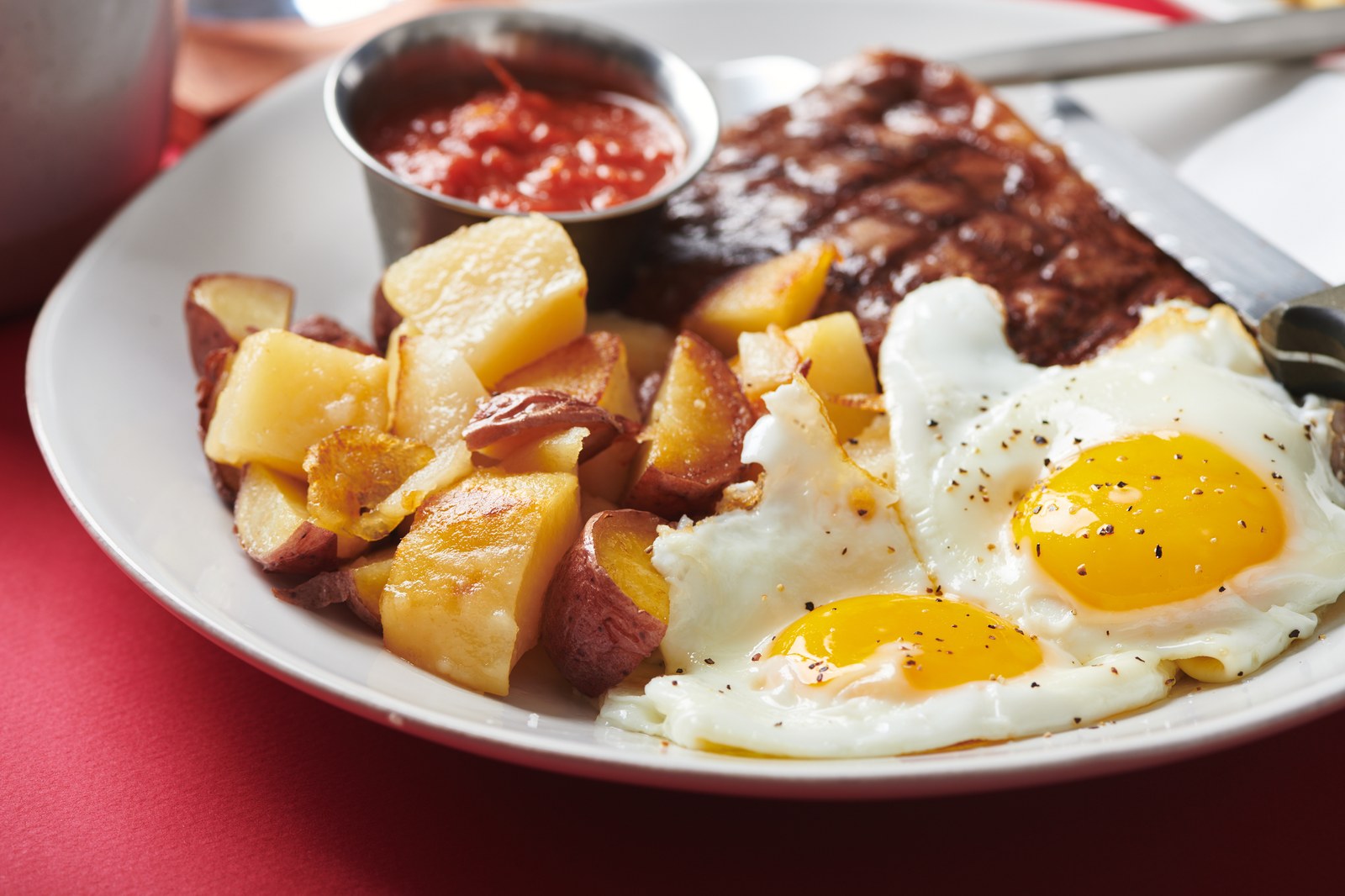 Grilled steak with fried eggs and crispy home fries