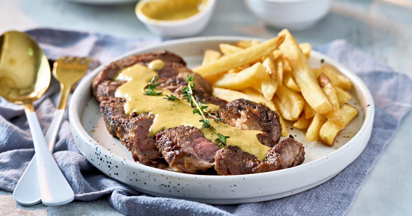 Sliced steak topped with béarnaise sauce served with french fries