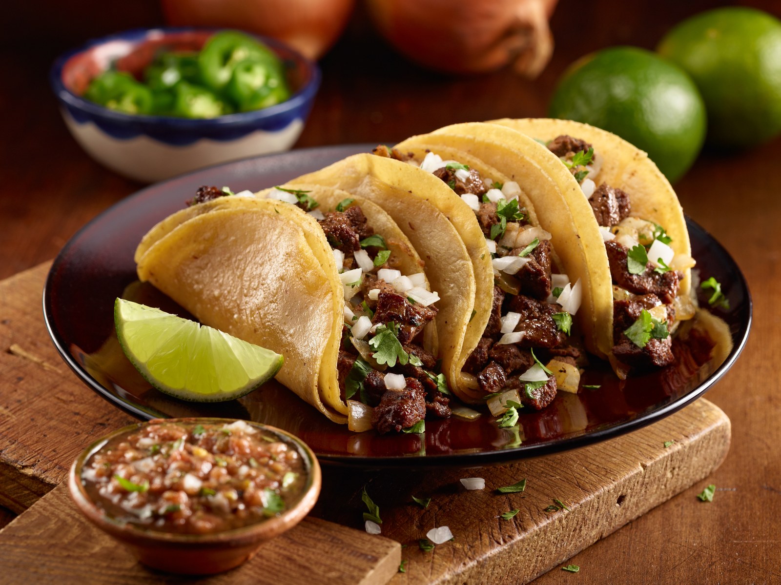 Corn tortilla tacos filled with seasoned steak, onions, and cilantro